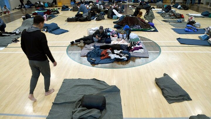 Migrants rest at a makeshift shelter in Denver
