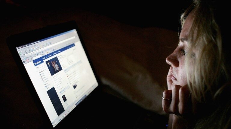 Click to enlarge Young woman browsing the social networking website Facebook