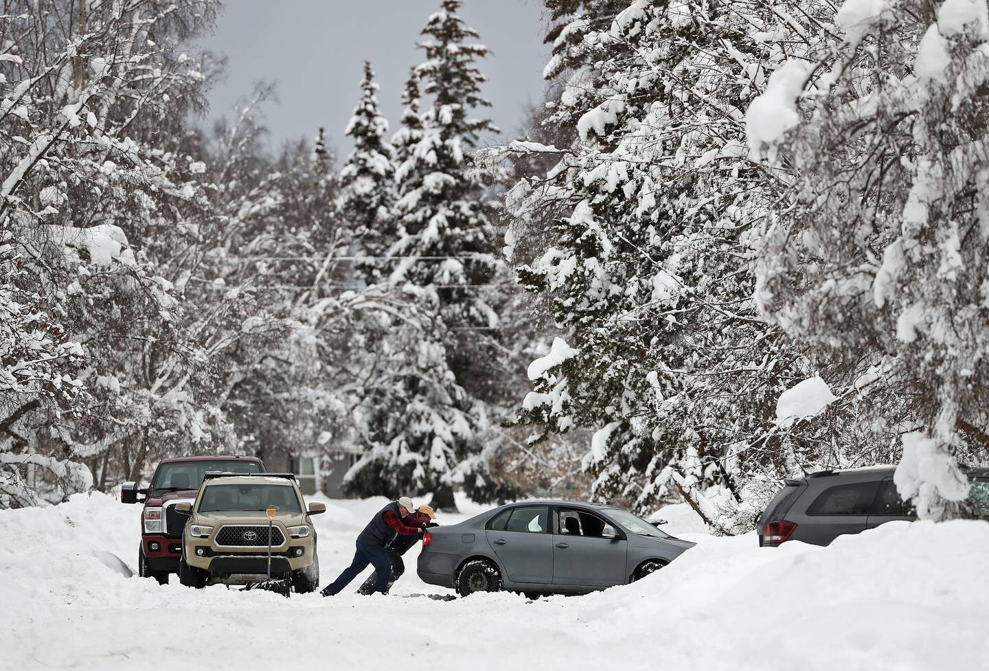 People help push a car after the car got stuck in