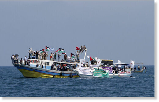 Palestinians waving national flags wait aboard small boats