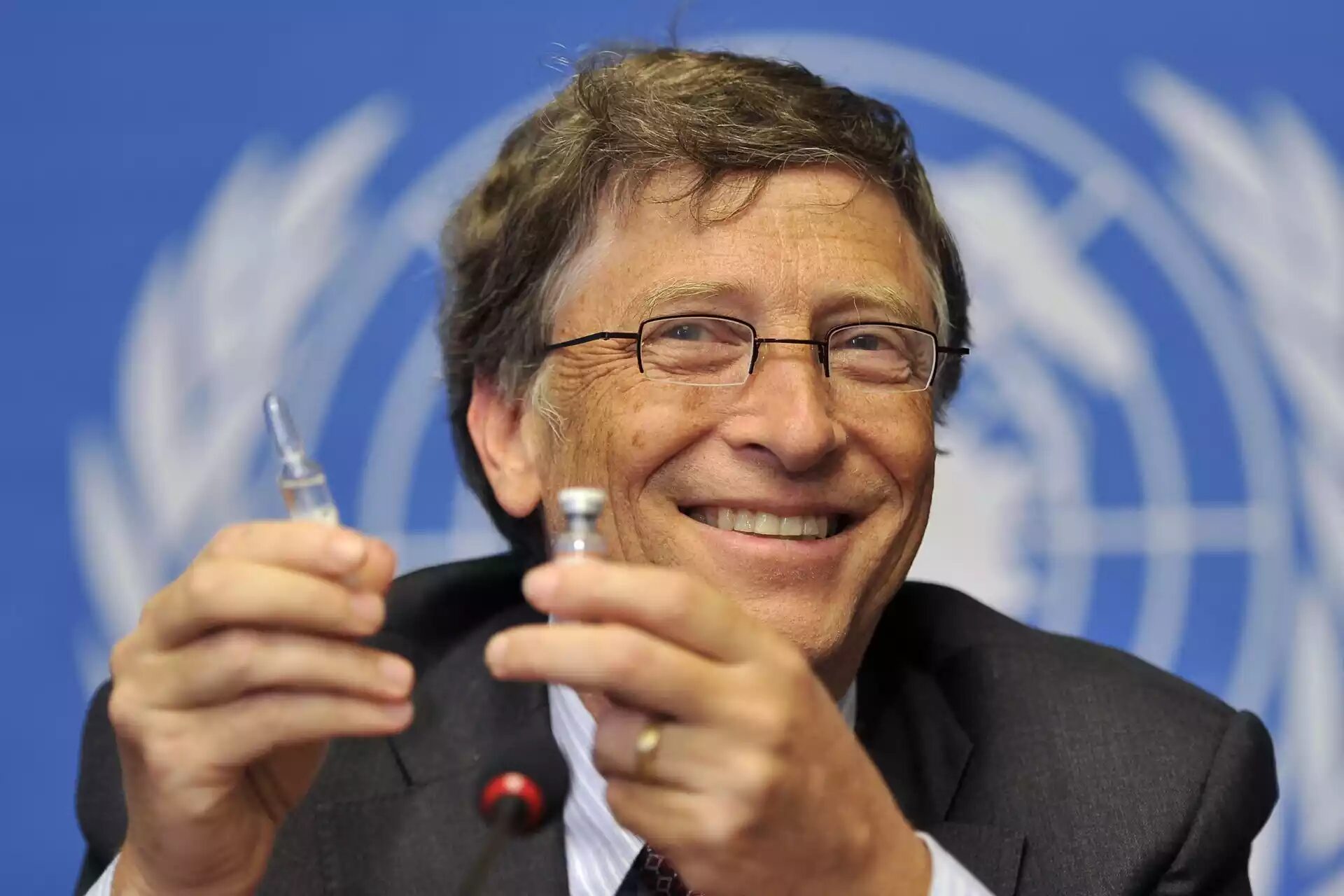 Bill Gates holds up a vaccine