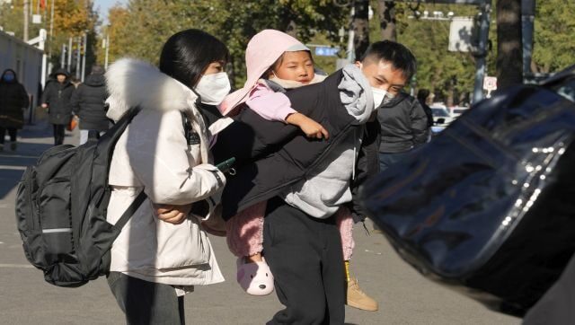man carries child Beijing