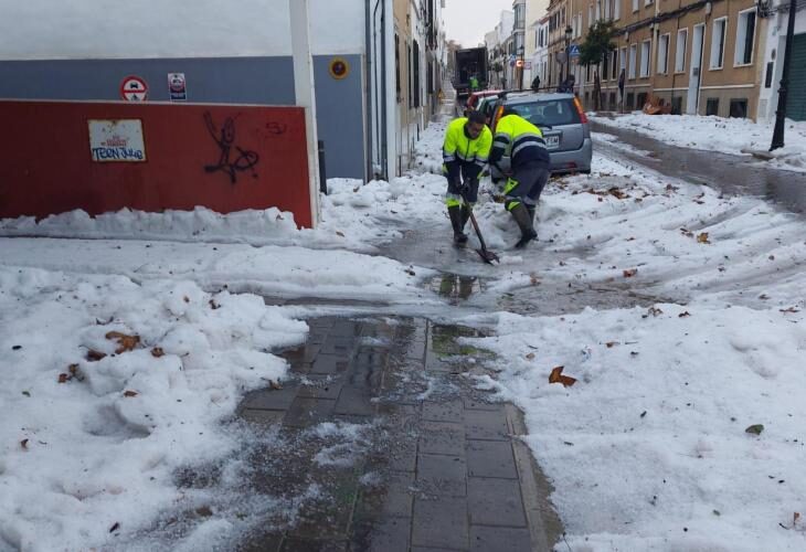 Municipal workers in Mahon clearing away the hail.