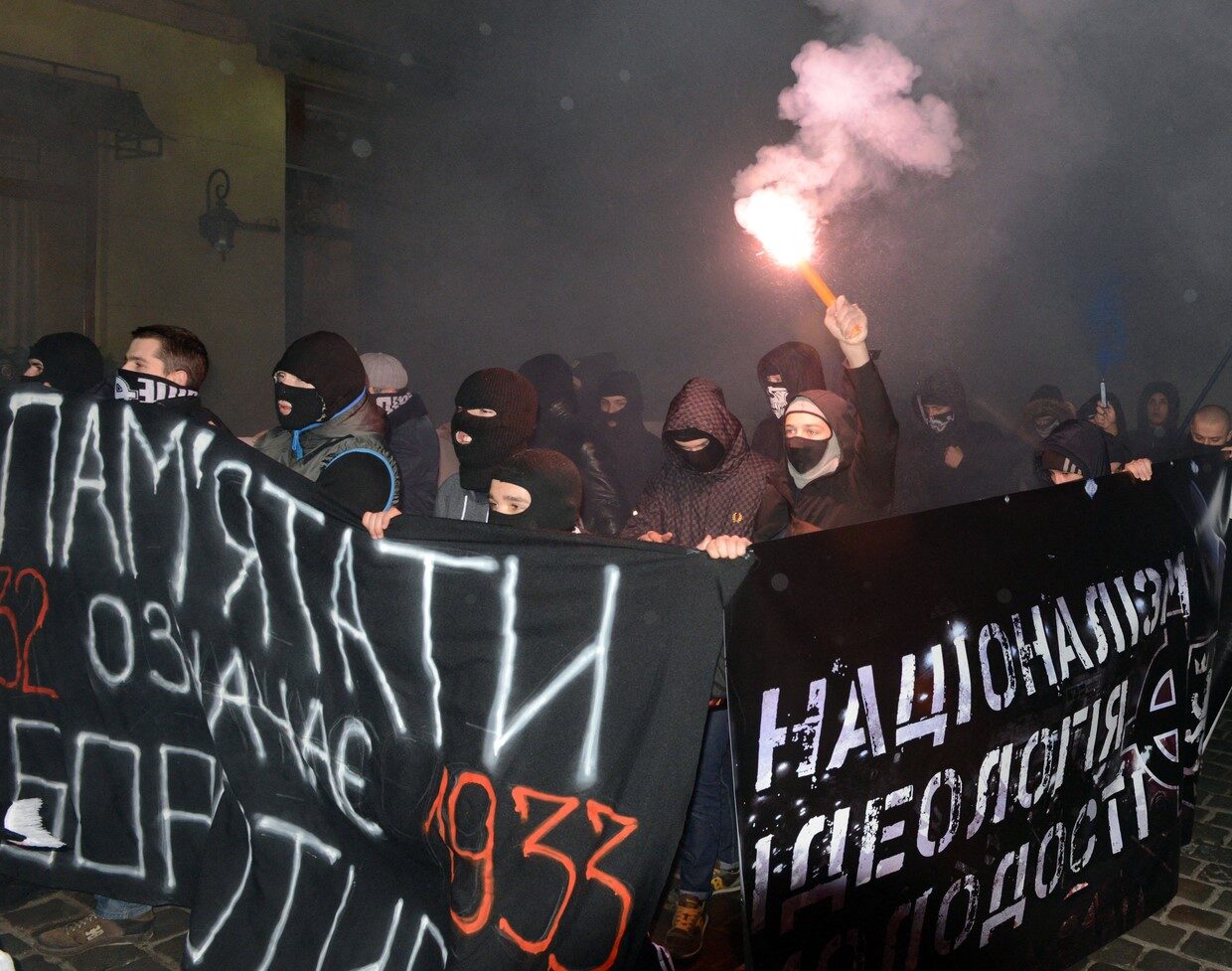 Click to enlarge Young ultra-nationalists carry placard reading