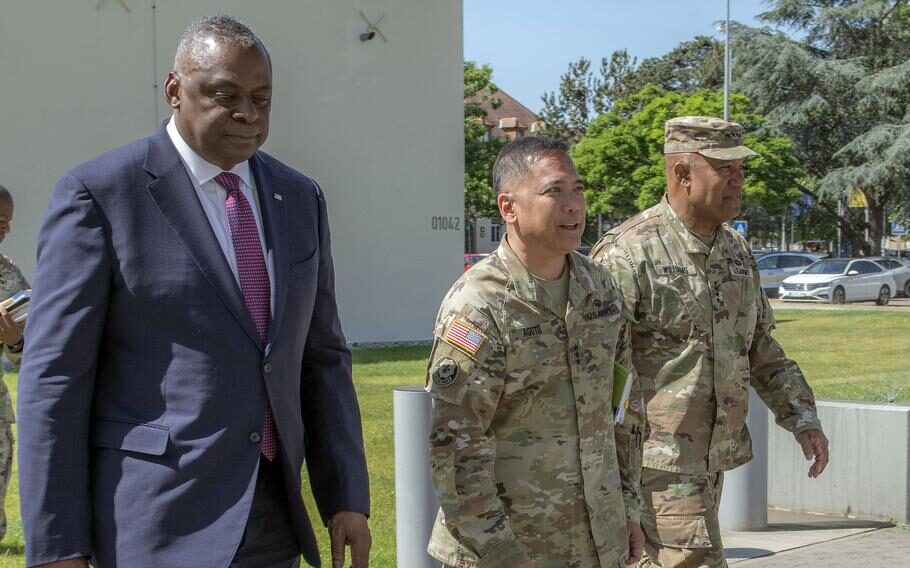 Antonio Aguto Jr., center, walks with Defense Secretary Lloyd Austin and U.S. Army Europe-Africa commander Gen. Darryl Williams