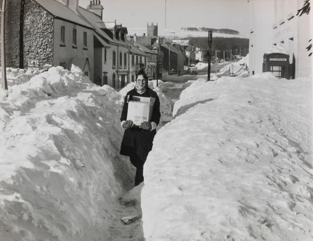 Robert McGregor, 11, carrying provisions through an opening cut in several feet of snow to Princetown in Dartmoor (