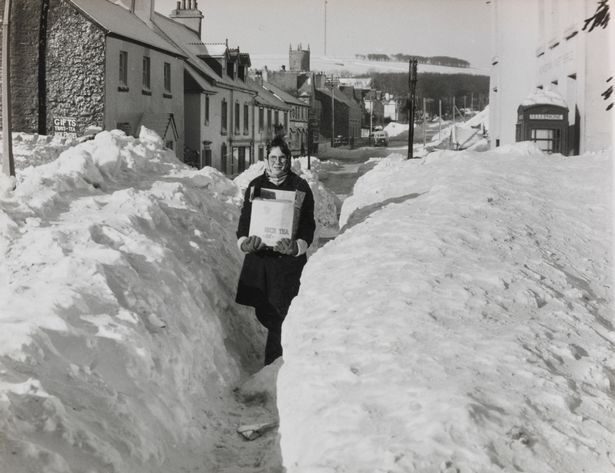 Click to enlarge Robert McGregor, 11, carrying provisions through an opening cut in several feet of snow to Princetown in Dartmoor (