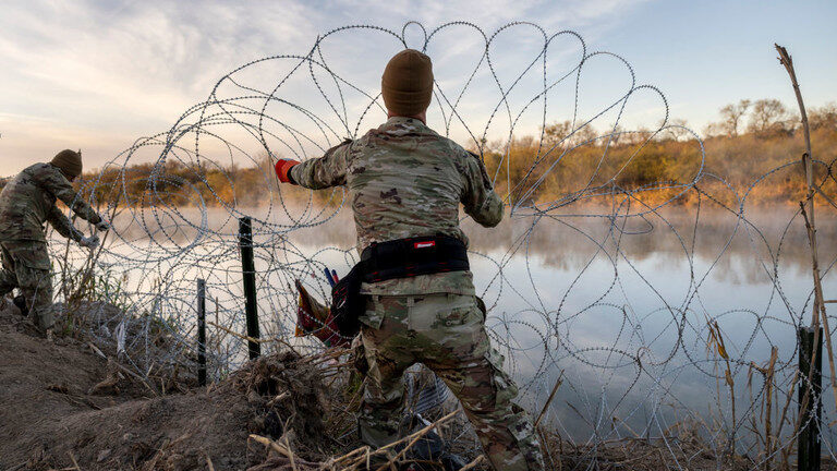 Click to enlarge Texas National Guard soldiers install razor wire