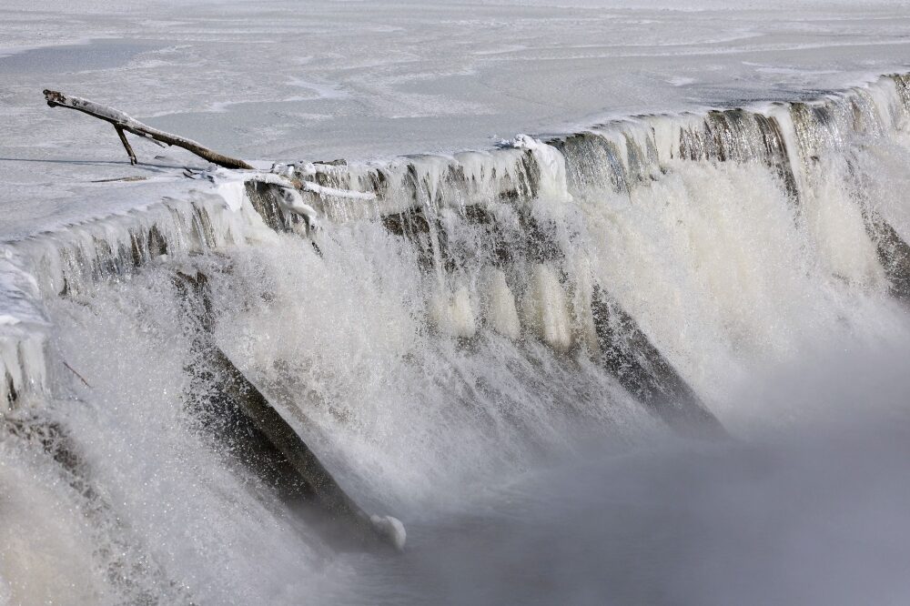 Ice forms along a dam built in the Des Moines River as temperatures remain below zero Fahrenheit on January 14, 2024, in Des Moines, Iowa.