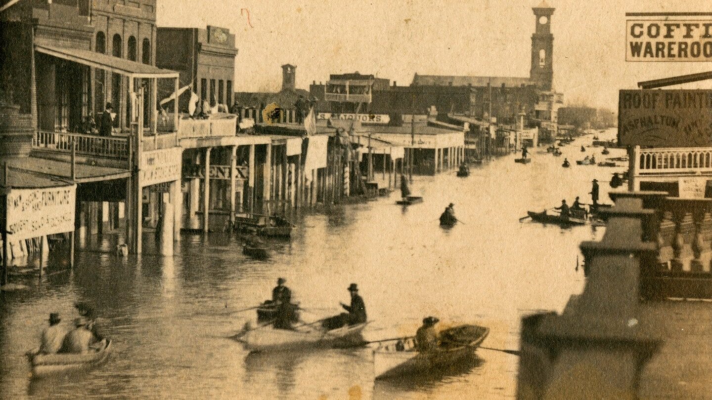 Shows buildings including Coffee Wareroom; flooded streets with men in rowboats in Sacramento, Calif. during 1861-62 floods.