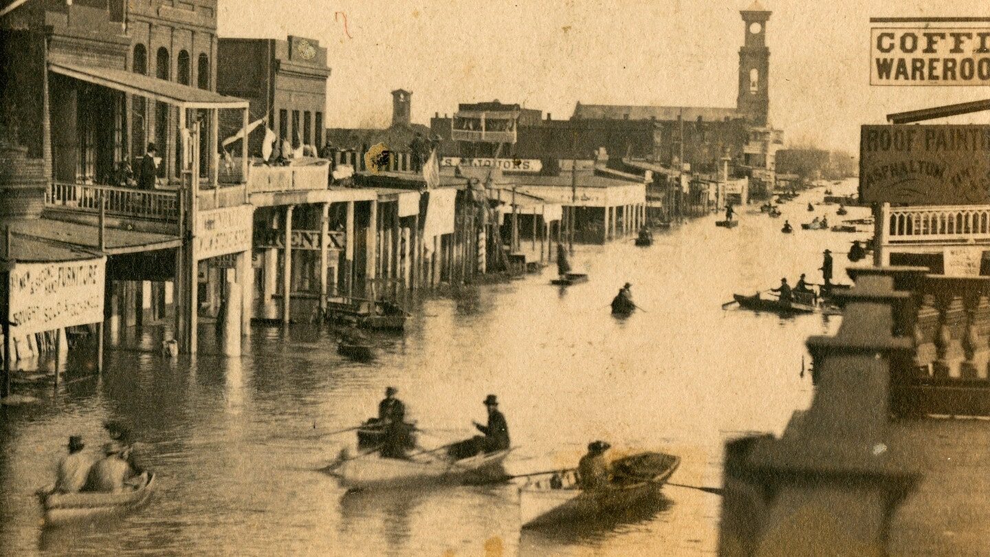 Click to enlarge Shows buildings including Coffee Wareroom; flooded streets with men in rowboats in Sacramento, Calif. during 1861-62 floods.