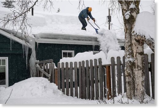 Russ DuBrock shovels his roof on Turnagain Parkway in Anchorage after a heavy snowfall on January 29, 2024.