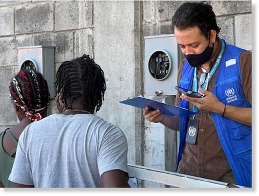 Click to enlarge UN workers help long lines of immigrants