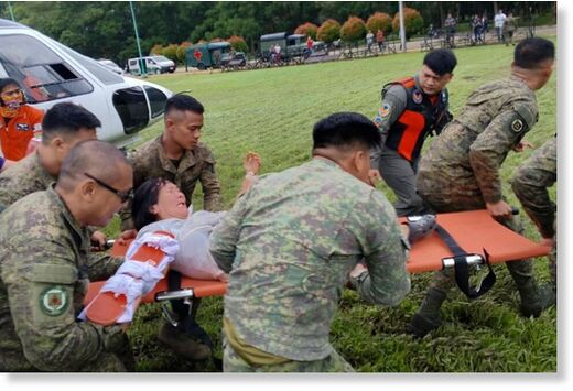 Volunteers assist residents being evacuated to safer grounds following a landslide at their village at Maco, Davao de Oro province, south Philippines