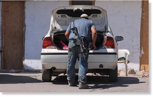 Click to enlarge An armed Israeli settler in the occupied West Bank.