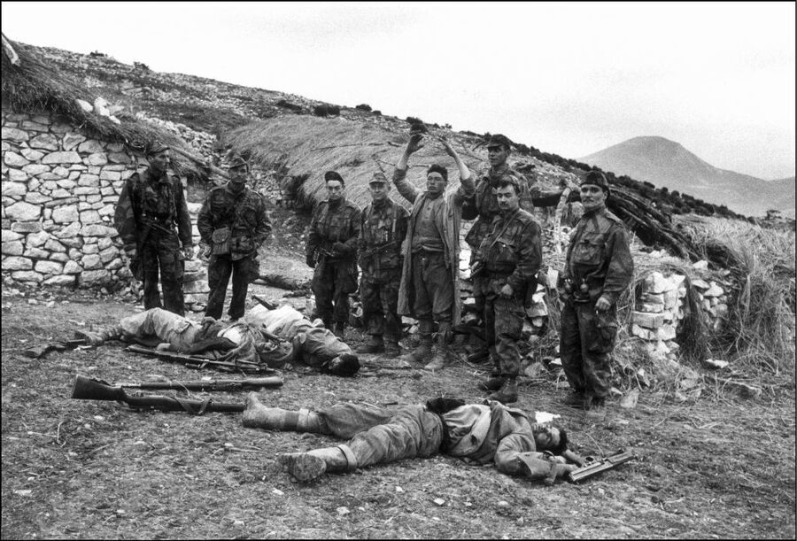 French soldiers looking at dead bodies during 
