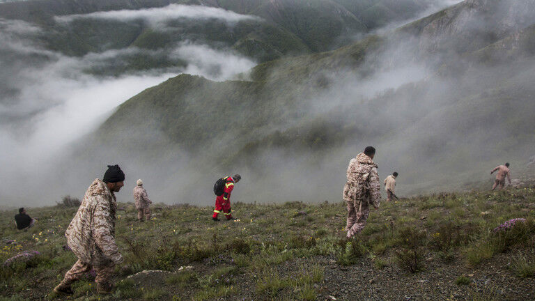 Rescue team members search an area near the crash site of a helicopter carrying Iranian President Ebrahim Raisi in Varzaghan, in northwestern Iran, on May 20, 2024.