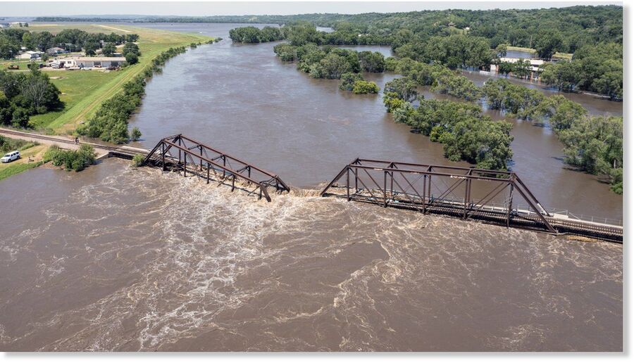 Click to enlarge Floodwaters pass over a collapsed railroad bridge over the Big Sioux River near North Sioux City, S.D., on Monday, June 24, 2024.