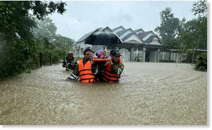 Click to enlarge Soldiers wade through a flooded street on Phu Quoc Island to carry a patient to hospital, July 14, 2024.
