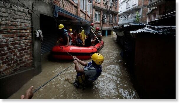 Click to enlarge Security force members use an inflatable raft to bring residents to safety from a flooded area near the bank of the overflowing Bagmati River following heavy rains, in Kathmandu, Nepal.
