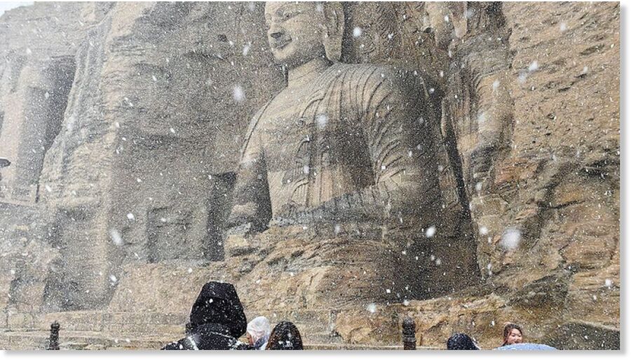 Tourists visit Yungang Grottoes in the snow on Tuesday in Datong, Shanxi province.