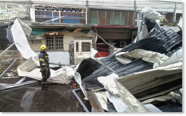 Click to enlarge Police check on roofing destroyed by the winds of Typhoon Kong-rey in Hualien County, eastern Taiwan, on Thursday