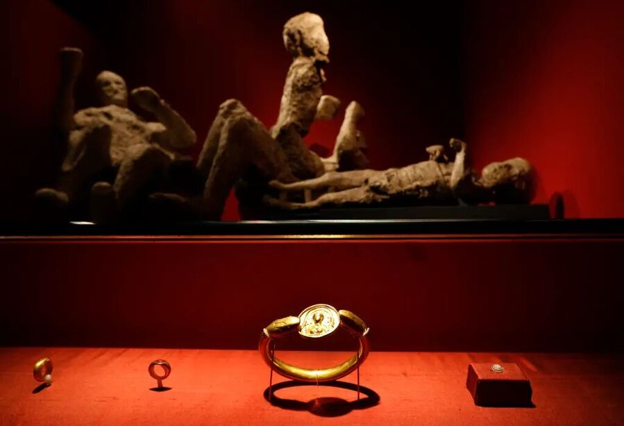 Click to enlarge Jewelry found in the ruins of a house in Pompeii, with casts of four victims in the background, on exhibit at the British Museum in central London.