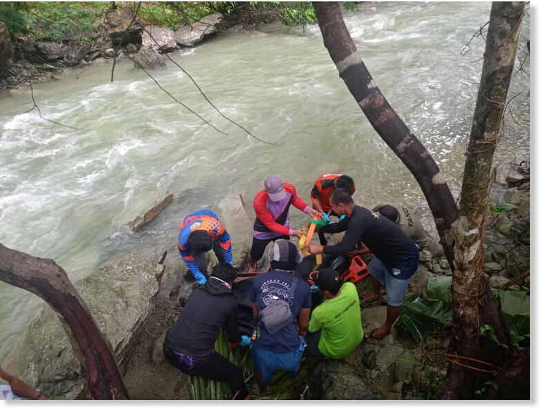 Rescuers place in a body bag the remains of an unidentified man found near Bilog Falls at Barangay Cabotonan in Lagonoy, Camarines Sur, on Friday amid heavy rains that triggered widespread flooding and landslides in the Bicol