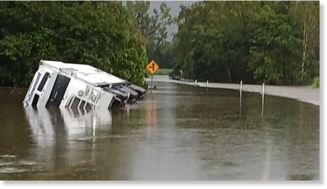 A truck attempted to drive through floodwaters until being swallowed by floodwaters north of Ingham on the Bruce Highway.