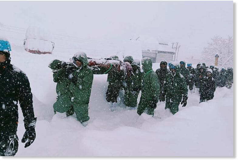 Rescuers carry workers after an avalanch