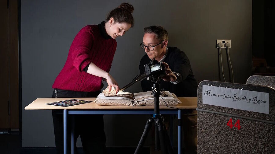 Click to enlarge Sally Kilby and Błażej Mikuła photograph inside the folds of a Medieval manuscript