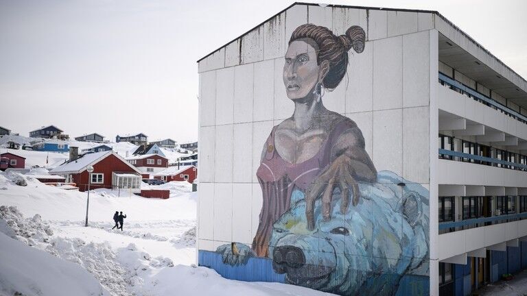 A mural depicting a woman and a polar bear on the end of residential block in Nuuk, Greenland.