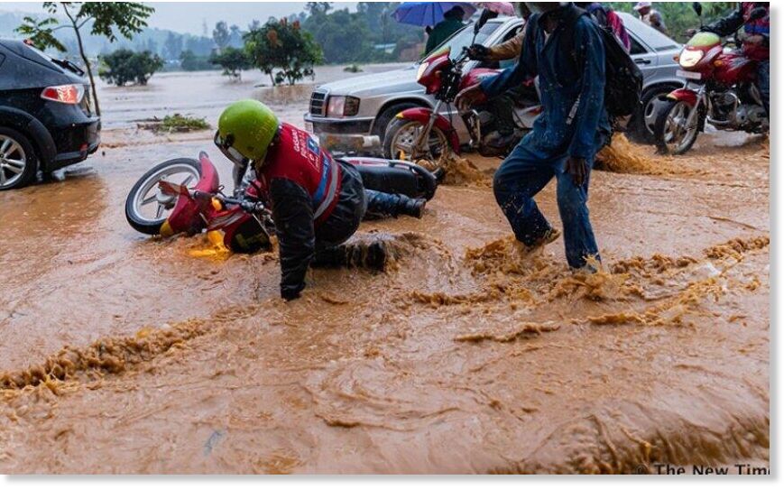 Click to enlarge Vehicles and people wade through a flooded street during heavy rains on Kinamba-Gakiriro-Kagugu road in Gasabo District in Kigali (file photo).