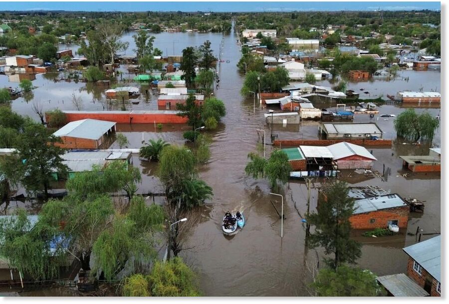 Boats move through flooded streets after heavy rain in Campana, Argentina,