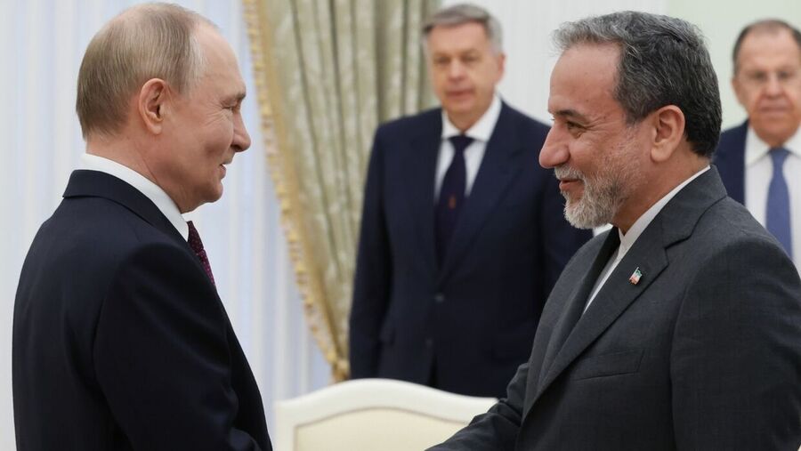 Russian President Vladimir Putin and Iranian Foreign Minister Abbas Araghchi shake hands before a meeting at the Kremlin