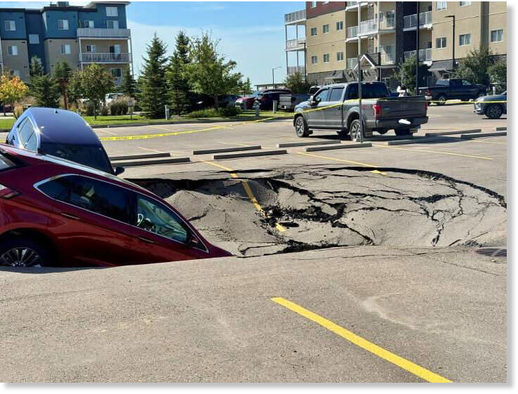 Two SUVs were left leaning into a sinkhole in the MacEwan Greens parking lot, located on the west side of Leduc, on Friday Aug. 1, 2025.