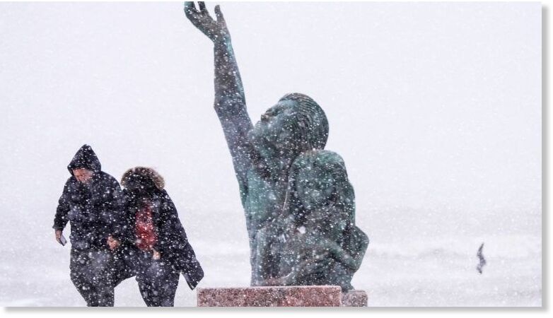 Click to enlarge People walk past the 1900 Storm memorial sculpture on Seawall Blvd. during an icy winter storm on Jan. 21, 2025, in Galveston, Texas.