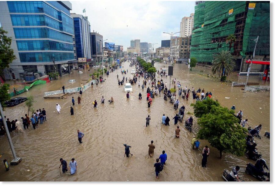 People wading through a flooded road after monsoon rain in Karachi, on Aug 19.