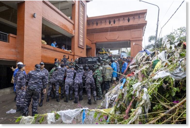 Click to enlarge Civilians and military personnel clean up a street after a deadly flood hit Denpasar, capital city of Bali, September 10, 2025