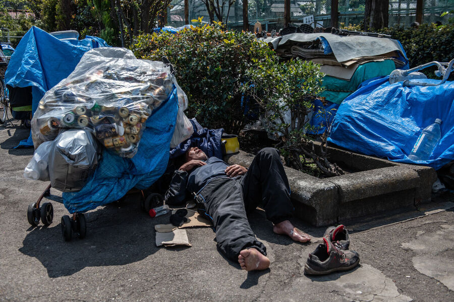 Click to enlarge homeless man sleeps in a park in Tokyo