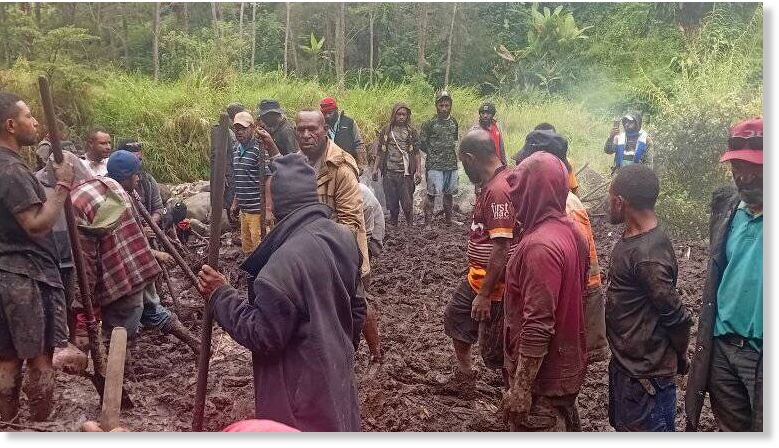 Click to enlarge Villagers work to recover bodies after a landslide in Papua New Guinea's Enga province.