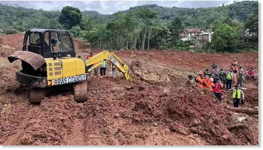 Click to enlarge An excavator digs through the soil in a search effort for landslide victims in Cibeunying Village, Cilacap Regency, Central Java, Friday, Nov. 14, 2025.