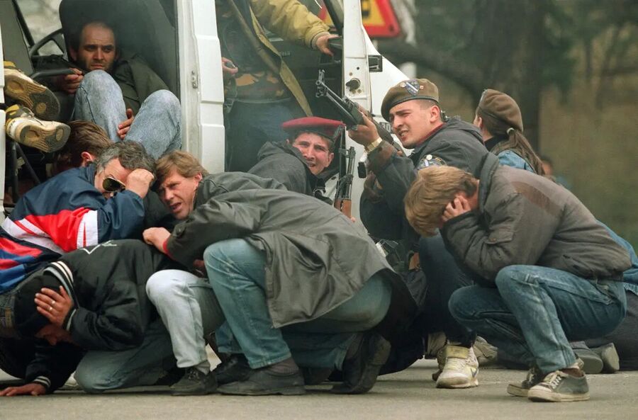 A Bosnian special forces soldier returns fire on April 6, 1992, in downtown Sarajevo as he and civilians come under fire from Serbian snipers.