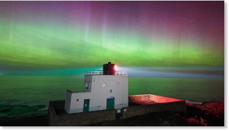 The aurora borealis above Bamburgh Lighthouse in Northumberland. Pic: PA