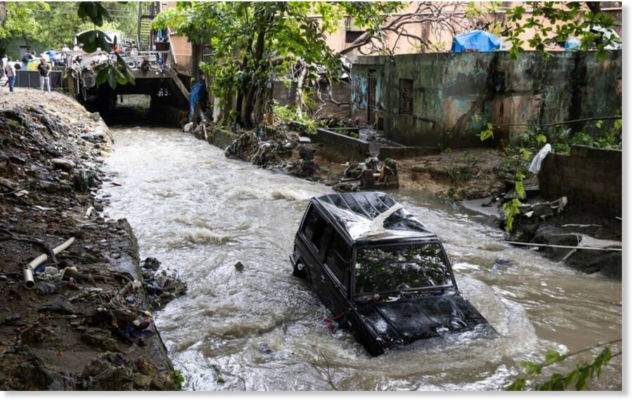 A vehicle is swept into a ravine by floodwaters in the Las 800 neighbourhood of Santo Domingo following heavy rain.