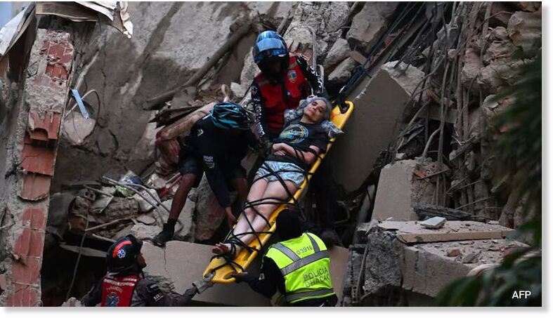 Rescue workers carry a person on a stretcher out of a collapsed building after two earthquakes struck Caracas.
