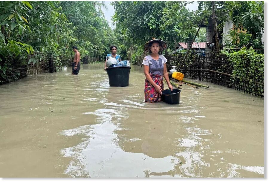 Residents wading through floodwaters in Kyauktaw, Myanmar's western Rakhine state on July 10.