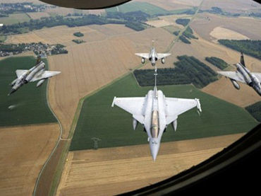 A French Rafale jet flanked by three Mirage 2000-N 