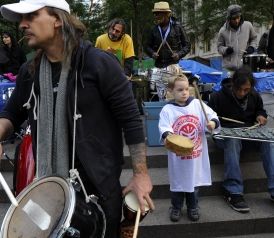 A child plays along with an Occupy Wall Street drum circle in Zuccotti Park on Sunday