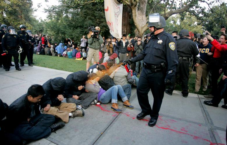 Click to enlarge A University of California Davis police officer pepper-sprays students